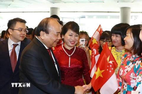 Cán bộ, nhân viên Đại sứ quán Việt Nam đón Thủ tướng Nguyễn Xuân Phúc và Phu nhân tại sân bay quốc tế Changi. (Ảnh: Thống Nhất/TTXVN)
