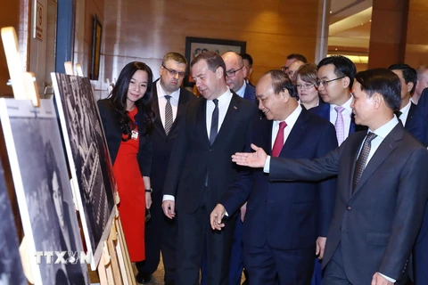 Thủ tướng Liên bang Nga Dmitry Medvedev và Thủ tướng Nguyễn Xuân Phúc tham quan Trưng bày ảnh Việt-Nga: Quan hệ hữu nghị truyền thống và hợp tác toàn diện. (Ảnh: Thống Nhất/TTXVN)