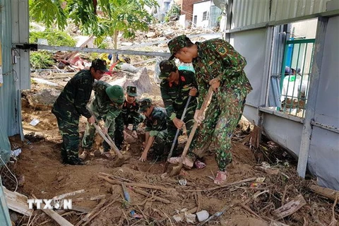 Các lực lượng quân đội hỗ trợ người dân khắc phục hậu quả do mưa lũ gây nên tại xã Phước Đồng, thành phố Nha Trang. (Ảnh: Phan Sáu/TTXVN)