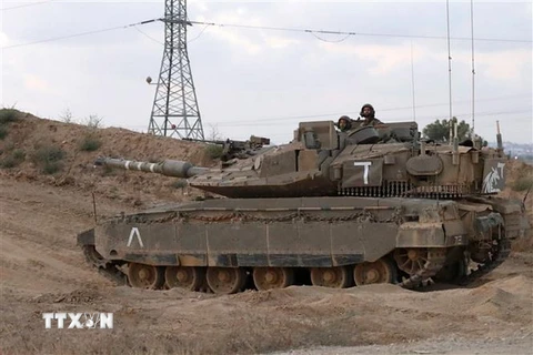 Binh sỹ và xe quân sự Israel được triển khai gần Kibbutz of Nahal Oz, giáp giới Dải Gaza. (Nguồn: AFP/TTXVN)