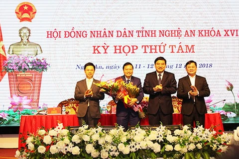 Lãnh đạo tỉnh tặng hoa chúc mừng ông Lê Hồng Vinh. (Nguồn: nghean.gov.vn)