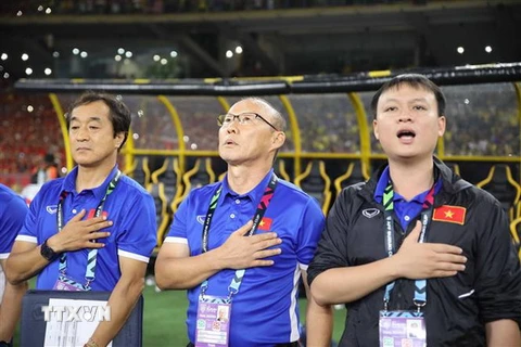 Huấn luyện viên Park Hang-seo (giữa) trong nghi thức chào cờ đầu trận chung kết lượt đi AFF Cup. (Ảnh: TTXVN)