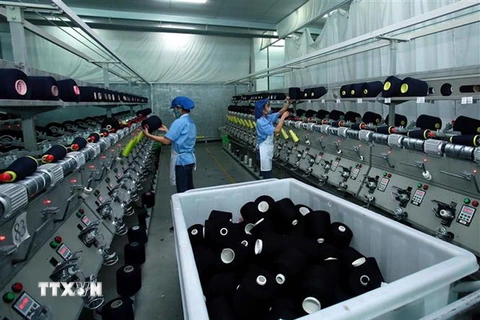 Sản xuất sợi tại Công ty TNHH Dệt nhuộm Jasan Việt Nam. (Ảnh: Phạm Kiên/TTXVN)