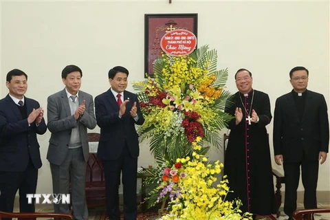 Chủ tịch Ủy ban Nhân dân thành phố Hà Nội Nguyễn Đức Chung tặng lẵng hoa, chúc mừng tân Tổng Giám mục Tổng Giáo phận Hà Nội Giuse Vũ Văn Thiên. (Ảnh: Lâm Khánh/TTXVN)