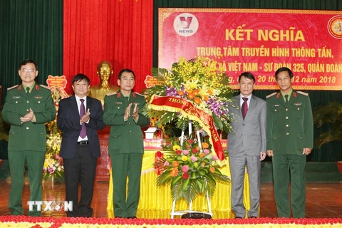 Tổng Giám đốc TTXVN Nguyễn Đức Lợi tặng hoa chúc mừng Bộ Tư lệnh Quân đoàn 2. (Ảnh: Dương Giang/TTXVN)