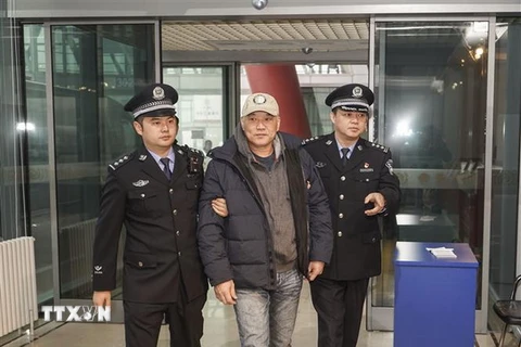 Cảnh sát Trung Quốc áp giải một cựu quan chức bị cáo buộc biển thủ công quỹ, sau khi đối tượng được dẫn độ từ Mỹ về tới Bắc Kinh. (Nguồn: THX/TTXVN)