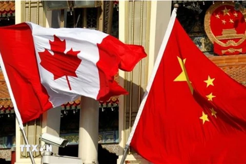 Quốc kỳ Canada (trái) và Quốc kỳ Trung Quốc tại Bắc Kinh. (Nguồn: South China Morning Post/TTXVN)