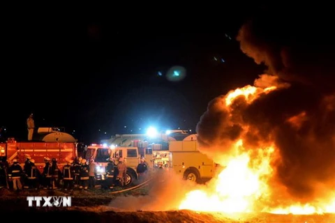 Lính cứu hỏa nỗ lực dập lửa tại hiện trường vụ nổ. (Nguồn: AFP/TTXVN)