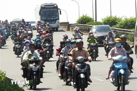 Dòng người đi xe máy đổ về TP.HCM trên Quốc lộ 1A, đoạn qua huyện Bình Chánh. (Ảnh: Hoàng Hải/TTXVN)