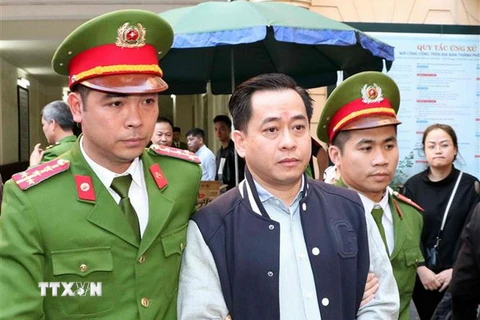 Cảnh sát dẫn giải bị cáo Phan Văn Anh Vũ sau khi Hội đồng xét xử kết thúc tuyên án. (Ảnh: Văn Điệp/TTXVN)