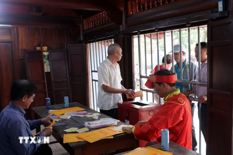 Các cụ cao niên phường Lộc Vượng, thành phố Nam Định (Nam Định) chuẩn bị ấn phát cho nhân dân, du khách. (Ảnh: Văn Đạt/TTXVN)