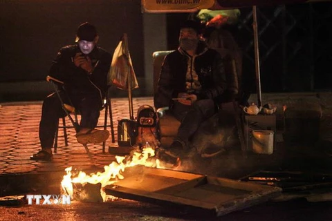 Người dân lao động đốt lửa, chống lại cái lạnh trong đêm. (Ảnh: Minh Hoàng/TTXVN phát)