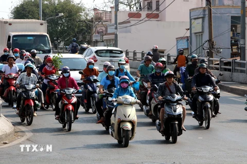 Phần đông người dân Thành phố Hồ Chí Minh đều trùm kín người khi đi ra đường trong những ngày nắng nóng. (Ảnh: Thanh Vũ/TTXVN)