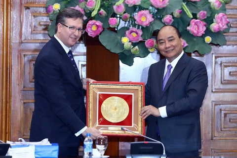 Thủ tướng Nguyễn Xuân Phúc tặng quà cho ông Alexander C. Feldmen, Chủ tịch, kiêm Tổng giám dốc điều hành Hội đồng kinh doanh Hoa Kỳ-ASEAN. (Ảnh: Thống Nhất/TTXVN)