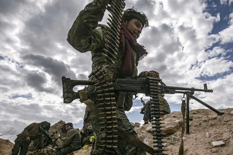 Một tay súng SDF được trang bị súng máy chuẩn bị tấn công vào làng Baghouz. (Nguồn: AFP)