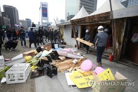 Các công nhân đang tháo dỡ, di dời các di ảnh khỏi địa điểm biểu tình tại quảng trường Gwanghwamun. (Nguồn: Yonhap)