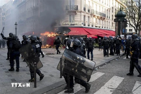 Người biểu tình Áo vàng đốt phá cửa hàng trên đại lộ Champs-Elysees ở Paris, Pháp. (Nguồn: THX/TTXVN)
