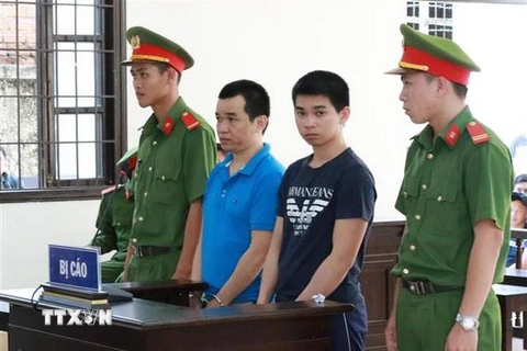 Hai bị cáo Huỳnh Tấn Lượng và Huỳnh Tấn Long tại tòa. (Ảnh: Nguyễn Thành/TTXVN)