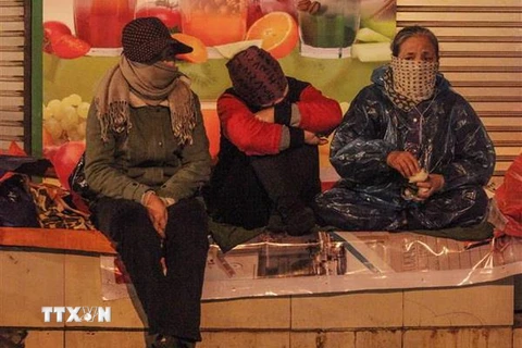 Người lao động co ro trong giá lạnh trên phố Tràng Thi, quận Hoàn Kiếm. (Ảnh: Minh Hoàng/TTXVN phát)