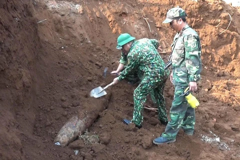 Lực lượng công binh xử lý quả bom được tìm thấy trong khu vực Trường Trung học phổ thông Cửa Tùng. (Ảnh: Nguyên Lý/TTXVN)