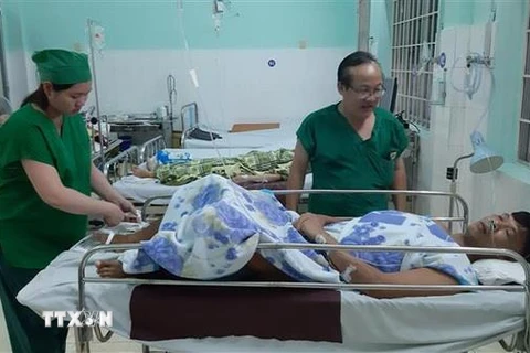 Các bác sỹ chăm sóc bệnh nhân Huỳnh Lý sau ca mổ. (Ảnh: Huỳnh Sơn/TTXVN)