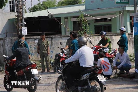 Lực lượng chức năng phong tỏa hiện trường vụ án. (Ảnh: Nguyễn Văn Việt/TTXVN)