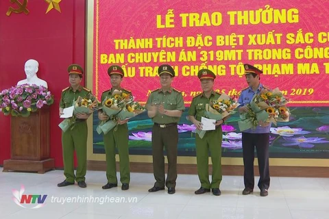Giám đốc Công an tỉnh Nguyễn Hữu Cầu trao thưởng cho Ban chuyên án. (Nguồn: truyenhinhnghean.vn)