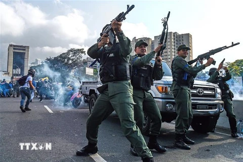 Các tay súng ủng hộ thủ lĩnh đối lập Venezuela Juan Guaido bắn chỉ thiên trong cuộc xung đột với lực lượng trung thành với Tổng thống Nicolas Maduro gần căn cứ quân sự La Carlota ở Caracas ngày 30/4. (Nguồn: AFP/TTXVN)