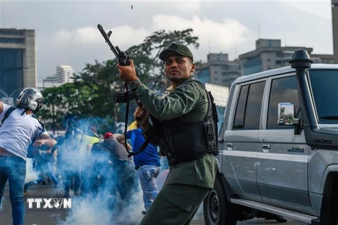 Tay súng thuộc nhóm binh sỹ ủng hộ thủ lĩnh đối lập Juan Guaido được trang bị vũ khí xung đột với lực lượng trung thành với Tổng thống Nicolas Maduro gần căn cứ quân sự La Carlota ở Caracas ngày 30/4. (Nguồn: AFP/TTXVN)