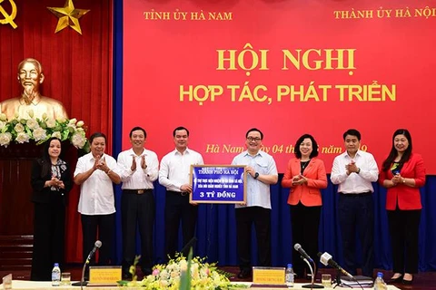 Lãnh đạo thành phố Hà Nội trao tặng Quỹ an sinh xã hội, xóa đói giảm nghèo tỉnh Hà Nam 3 tỷ đồng. (Nguồn: hanoi.gov.vn)