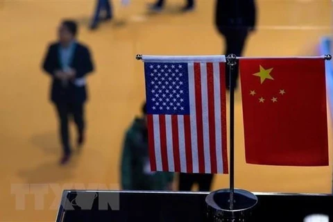 Cờ Mỹ (trái) và cờ Trung Quốc (phải) tại một gian hàng ở Triển lãm nhập khẩu quốc tế Trung Quốc. (Ảnh: AFP/ TTXVN)