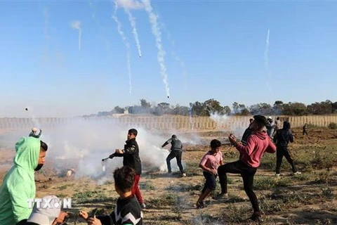 Binh sỹ Israel bắn đạn hơi cay về phía người biểu tình Palestine trong cuộc đụng độ tại khu vực biên giới Israel và Dải Gaza ngày 19/4. (Nguồn: THX/TTXVN)