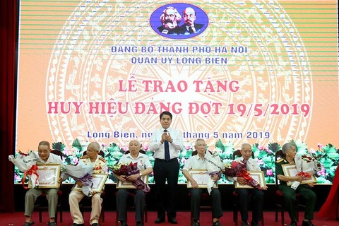 Chủ tịch UBND thành phố Nguyễn Đức Chung trao Huy hiệu Đảng cho các đảng viên lão thành. (Nguồn: hanoi.gov.vn)