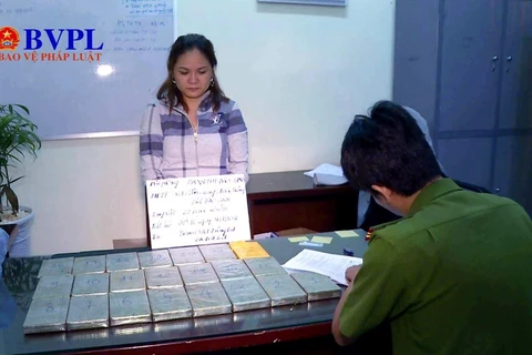 Phan Thị Đào cùng tang vật 22 bánh heroin tại cơ quan điều tra. (Nguồn: baovephapluat.vn)