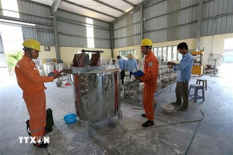 Công nhân Công ty Điện lực Hải Dương (Tổng Công ty Điện lực miền Bắc) khảo sát nhu cầu điện năng một cơ sở sản xuất gốm Chu Đậu. (Ảnh: Ngọc Hà/TTXVN)