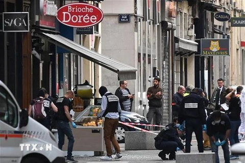 Cảnh sát Pháp điều tra tại hiện trường vụ nổ gói bưu kiện nghi là bom trên phố đi bộ ở Lyon. (Nguồn: AFP/TTXVN)