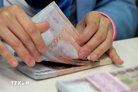 Kiểm tiền baht tại ngân hàng Krung Thai ở Bangkok, Thái Lan. (Nguồn: AFP/TTXVN)