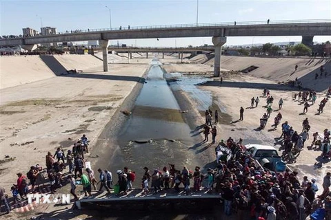Người di cư Trung Mỹ qua sông Tijuana để tới cửa khẩu El Chaparral ở Tijuana, bang Baja California, Mexico, gần biên giới Mỹ-Mexico. (Nguồn: AFP/TTXVN)