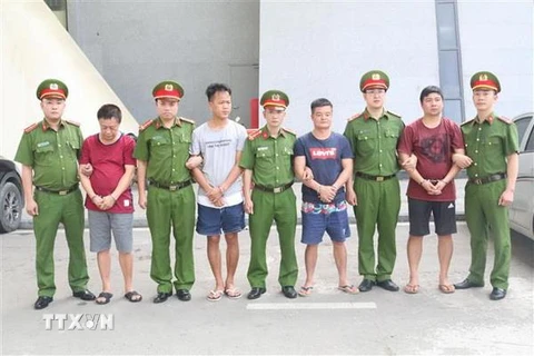 Các đối tượng bị truy nã người Trung Quốc được trao trả cho Công an Trung Quốc. (Ảnh: Ngọc Tùng/TTXVN)