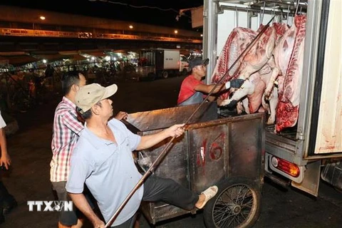 Thịt lợn chuẩn bị được đưa đi tiêu thụ tại chợ đầu mối nông sản thực phẩm Hóc Môn. (Ảnh: Đinh Hằng/TTXVN)