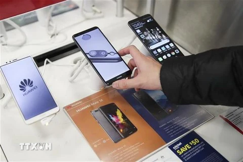 Khách hàng tìm hiểu về điện thoại thông minh của Tập đoàn công nghệ viễn thông Huawei tại một cửa hàng ở New York, Mỹ. (Nguồn: THX/TTXVN)