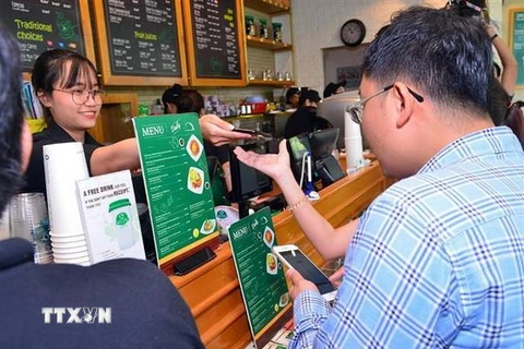 Nhiều hệ thống nhà hàng, cửa hàng chấp nhận thanh toán không dùng tiền mặt qua Ví điện tử MoMo. (Ảnh: TTXVN phát)