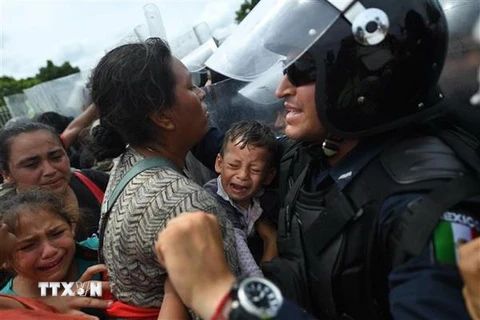 Cảnh sát ngăn chặn người di cư tại cây cầu ở biên giới Guatemala-Mexico, Ciudad Hidalgo, bang Chiapas, Mexico. (Nguồn: AFP/TTXVN)