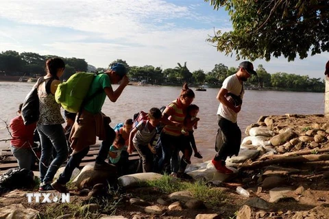 Người di cư vượt sông Suchiate từ Tecun Uman (Guatemala) để tới Ciudad Hidalgo, Chiapas (Mexico), trong hành trình tới Mỹ. (Nguồn: AFP/TTXVN)
