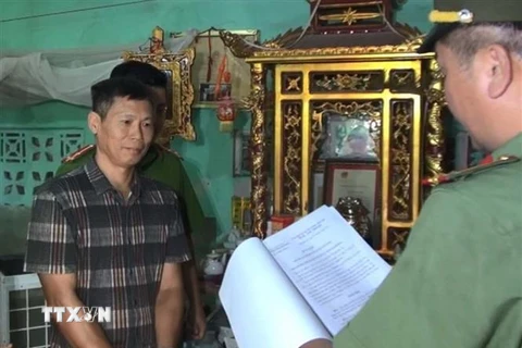 Lực lượng chức năng đọc lệnh bắt tạm giam đối với Phạm Văn Điệp. (Ảnh: Trịnh Duy Hưng/TTXVN)