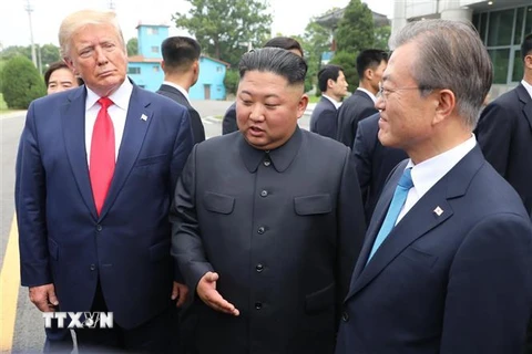 Tổng thống Mỹ Donald Trump, nhà lãnh đạo Triều Tiên Kim Jong-un (giữa) và Tổng thống Hàn Quốc Moon Jae-in (phải) trong cuộc gặp tại Khu phi quân sự (DMZ) ngày 30/6. (Ảnh: THX/TTXVN)