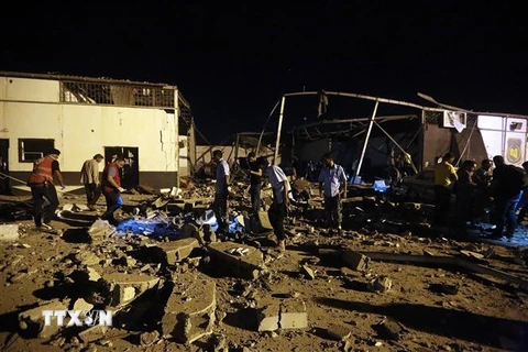 Chuyển thi thể nạn nhân tại hiện trường vụ không kích nhằm vào khu tạm giữ người di cư ở Tajoura, ngoại ô thủ đô Tripoli, Libya. (Nguồn: AFP/TTXVN)