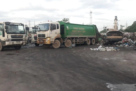 Công ty CP dịch vụ môi trường Thăng Long đang huy động tối đa phương tiện, nhân lực để thu dọn rác tồn đọng trên địa bàn quận Hoàng Mai. Ảnh Mạnh Khánh/TTXVN)