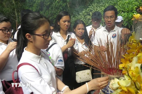 Đoàn thanh niên, sinh viên kiều bào dâng hương trước mộ cụ Huỳnh Thúc Kháng. (Ảnh: Phước Ngọc/TTXVN)