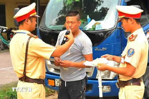 Lực lượng Cảnh sát giao thông huyện Nho Quan kiểm tra nồng độ cồn với lái xe. (Ảnh: Minh Đức/TTXVN)